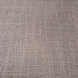 May include: A light beige fabric with a visible woven texture. The material features a grid-like pattern created by interlacing threads, resulting in a consistent, slightly raised surface appearance across the entire textile surface.