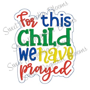 Può includere: Disegno ricamato con il testo "For this child we have prayed" in un carattere colorato. Le parole sono in un cerchio con un contorno blu.