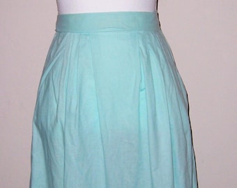 May include: A light blue pleated skirt with a simple design. The skirt is made of a smooth, lightweight fabric.
