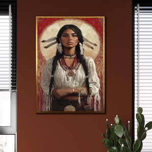 Op de afbeelding: Een ingelijst portret van een inheemse Amerikaanse vrouw. Ze draagt een witte blouse, kralenkettingen en veren versieringen in haar donkere gevlochten haar. De achtergrond heeft een rood en goud ontwerp en de lijst is goud.