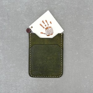 Leather card holder made of olive colored top grain Italian leather and cream colored durable Japanese thread, completely hand-sewn without using any machines. It has a soft and high-quality texture and a wonderful scent.Wıth quality certificate
