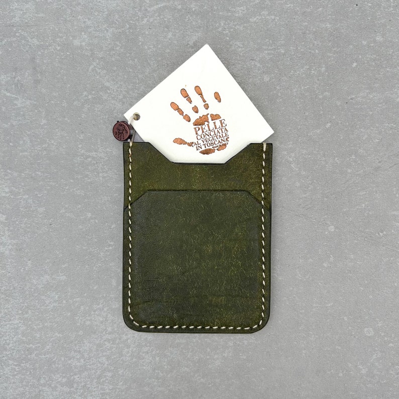 Leather card holder made of olive colored top grain Italian leather and cream colored durable Japanese thread, completely hand-sewn without using any machines. It has a soft and high-quality texture and a wonderful scent.Wıth quality certificate
