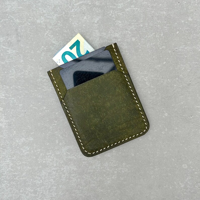 Leather card holder made of olive colored top grain Italian leather and cream colored durable Japanese thread, completely hand-sewn without using any machines. It has a soft and high-quality texture and a wonderful scent. Wıth some cash and card