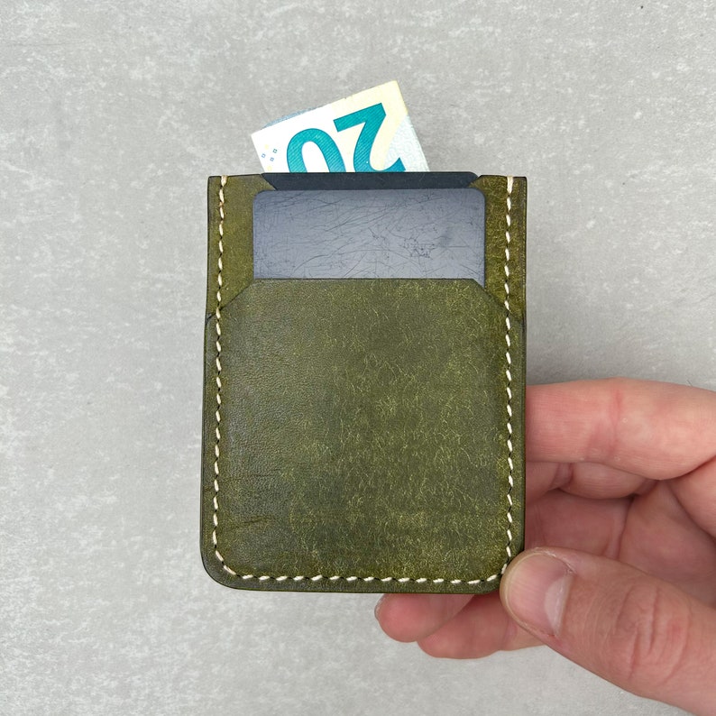 Leather card holder made of olive colored top grain Italian leather and cream colored durable Japanese thread, completely hand-sewn without using any machines. It has a soft and high-quality texture and a wonderful scent.Image in hand