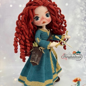 以下が含まれることがあります： 赤い巻き毛、青い目、金色のトリムが付いたティールグリーンのドレスを着た手作りの編み人形。人形は弓矢を持ち、茶色の矢筒を持っています。人形は人気のアニメ映画のキャラクターです。