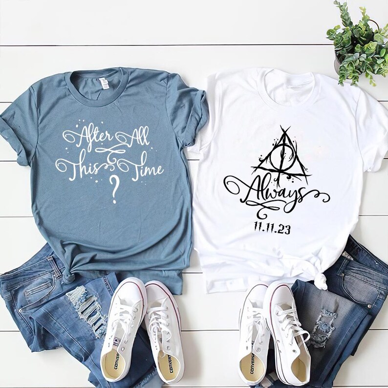May include: Two t-shirts, one blue and one white, with text and a graphic. The blue shirt says "After All This Time?" in white text. The white shirt has a black graphic of the Deathly Hallows symbol with the text "Always" and "11.11.23" underneath.