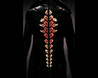 Puede incluir: Abrigo largo negro con cuello alto y un diseño decorativo en forma de espina dorsal de color naranja brillante en la espalda. El abrigo parece estar hecho de un material similar al cuero. El diseño es simétrico y detallado.