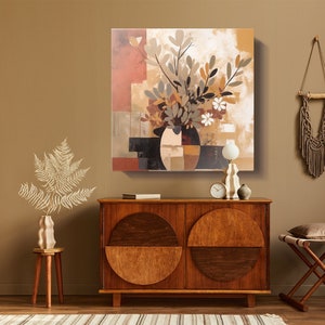 May include: Abstract painting of a vase with flowers in shades of brown, white, and gray. The vase is surrounded by geometric shapes in black, brown, and white. The painting is on a canvas and is framed.