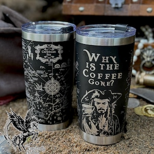 May include: Two black stainless steel travel mugs with silver rims and lids. One mug features a map of the Caribbean Sea, the other has a pirate illustration and the text "Why is the coffee gone?"
