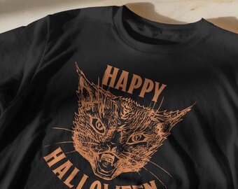 May include: Black t-shirt with a distressed orange graphic of a cat's face, with the words "HAPPY HALLOWEEN" arched above and below the cat's head. The cat has an open mouth and sharp teeth.