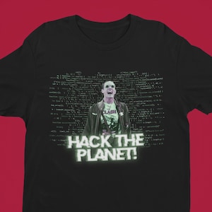 May include: Black t-shirt with a green and white image of a person with a microphone and the text "Hack the Planet!" printed on the front.