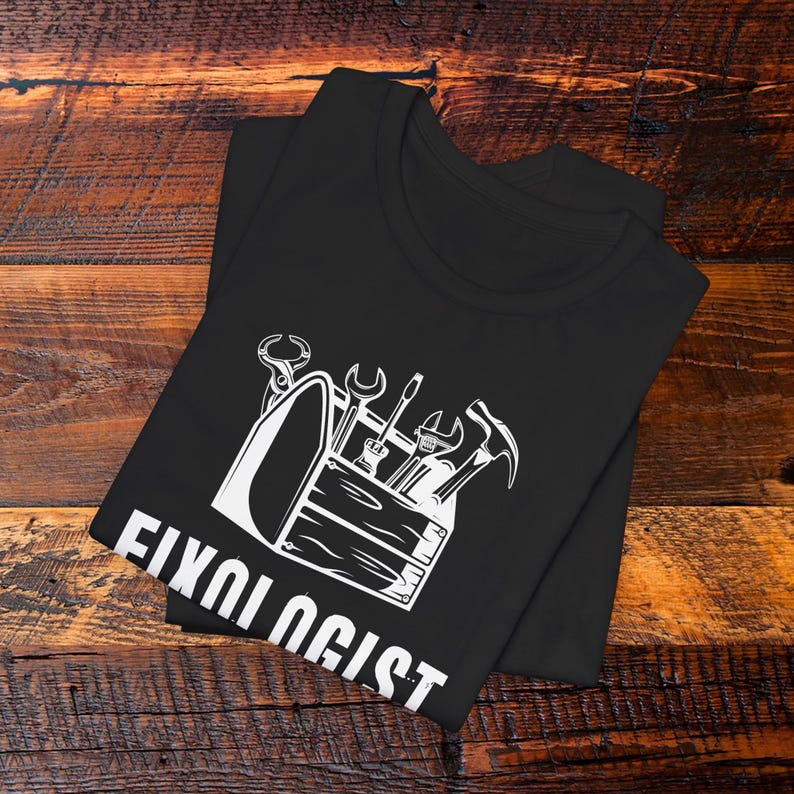 May include: Black t-shirt with a white graphic of a toolbox with tools and the text "Fixologist".