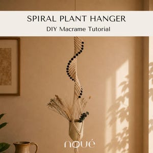 May include: A spiral plant hanger featuring off-white macrame cord and black beads, suspended from above. The text SPIRAL PLANT HANGER DIY Macrame Tutorial is visible at the top, and the word noué is printed at the bottom of the hanger.