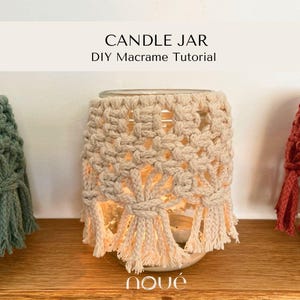 Könnte beinhalten: Ein durchsichtiges Kerzenglas aus Glas, umhüllt von einer cremefarbenen Makramee-Hülle mit geknotetem geometrischem Muster und gefranstem unteren Rand. Der Text CANDLE JAR DIY Macrame Tutorial und das Wort noué sind zu sehen.