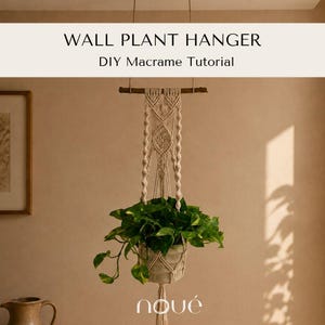 Könnte beinhalten: Ein cremefarbener Makramee-Wandpflanzenhänger, der an einem dunklen Holzast hängt, mit komplizierten Knotenmustern und einer grünen Blattpflanze in einem Topf. Der Text lautet WALL PLANT HANGER DIY Macrame Tutorial.