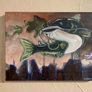 May include: An original painting of a catfish with a green and white body, set against a backdrop of a cityscape and falling leaves. The artwork is signed "H. FANNIN '21". The painting is on a canvas.