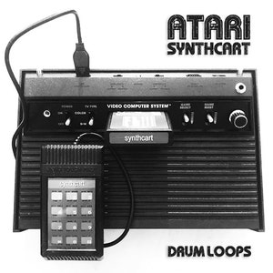 以下が含まれることがあります： アターリのビデオゲームコンソールと、それに接続された白黒のキーボードの白黒画像。コンソールには、「VIDEO COMPUTER SYSTEM」と「synthcart」と書かれたラベルが付いています。キーボードには、「synthcart」と「VIDEO TOUCH PAD」と書かれたラベルが付いています。画像には、「ATARI SYNTHCART」と「DAUM LOOPS」のテキストも含まれています。