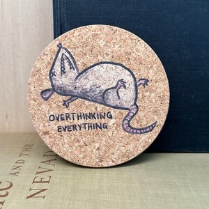 round coaster with an exhausted possum saying over thinking everything