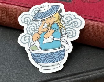 May include: A sticker featuring a cartoon illustration of a girl with blonde hair wearing a blue dress and a blue and white hat sitting in a blue and white bowl with a swirling pattern. The girl is surrounded by white clouds.