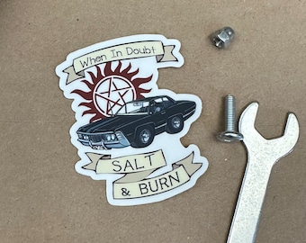 May include: A white sticker with a black car, a red pentagram with a sunburst behind it, and the text "When In Doubt Salt & Burn".
