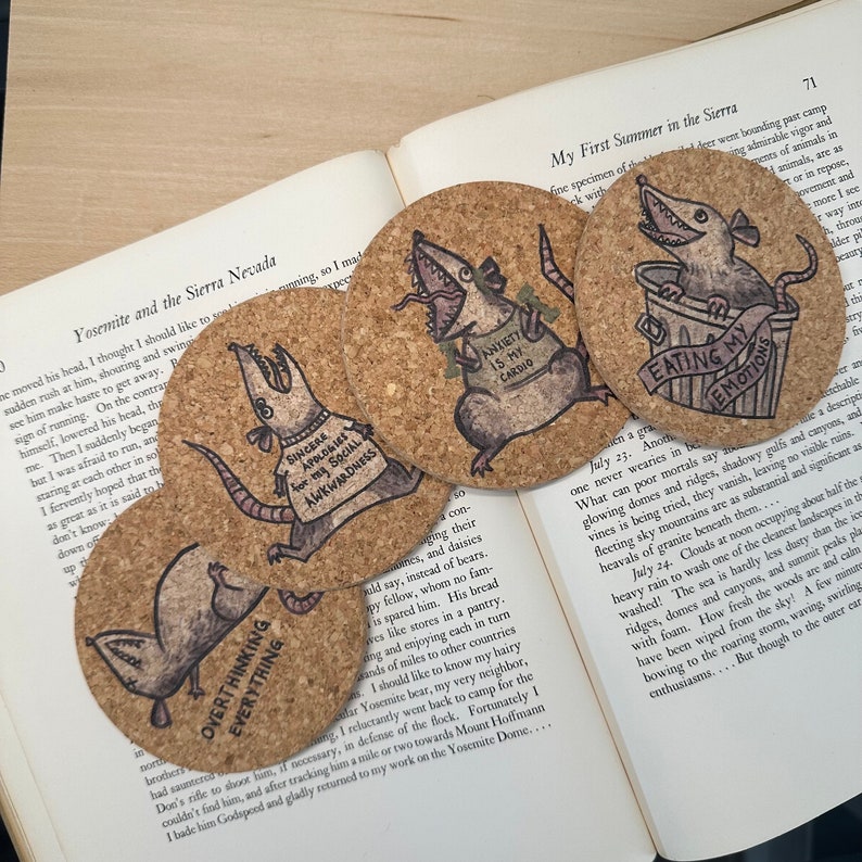 four circular cork coasters featuring images of an awkward possum with sayings such as over thinking everything, eating my emotions, apologies for my social awkwardness, and anxiety is my cardio