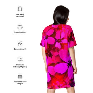 May include: A pink and red floral print t-shirt dress with a relaxed fit and above-the-knee length. The dress has drop shoulders and a comfortable fit.