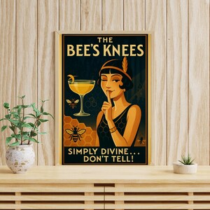 May include: Art Deco style poster with the text "THE BEE'S KNEES" and "SIMPLY DIVINE... DON'T TELL!". The poster features a woman in a black dress with a finger to her lips, a cocktail, and bee illustrations. The background is dark blue and gold.