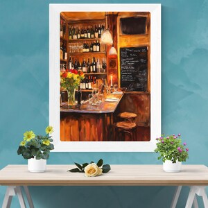 May include: A watercolor painting of a bar interior with a wooden counter, shelves stocked with wine bottles, and two bar stools. The bar is lit by a warm, yellow light, and there are flowers in a vase on the counter. The painting is framed in a white frame.