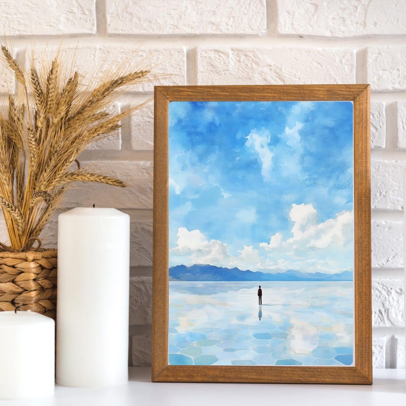 May include: A framed watercolor painting of a lone figure standing in a vast, reflective body of water. The sky is a bright blue with fluffy white clouds. The mountains in the distance are a hazy blue.