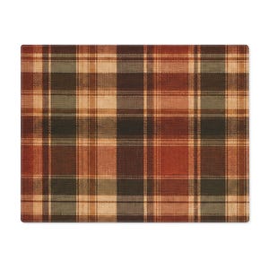 May include: A rectangular placemat featuring a woven plaid pattern in shades of deep red, forest green, and cream. The fabric displays a textured surface with intersecting horizontal and vertical lines forming a classic grid design throughout the piece.