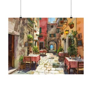 Op de afbeelding: Aquarelprint van een Europese straatscène met buiteneethoeken. Tafels met rood-wit geblokte tafelkleden staan langs een geplaveide straat. Gebouwen in tinten geel, roze en oranje omzomen de straat.