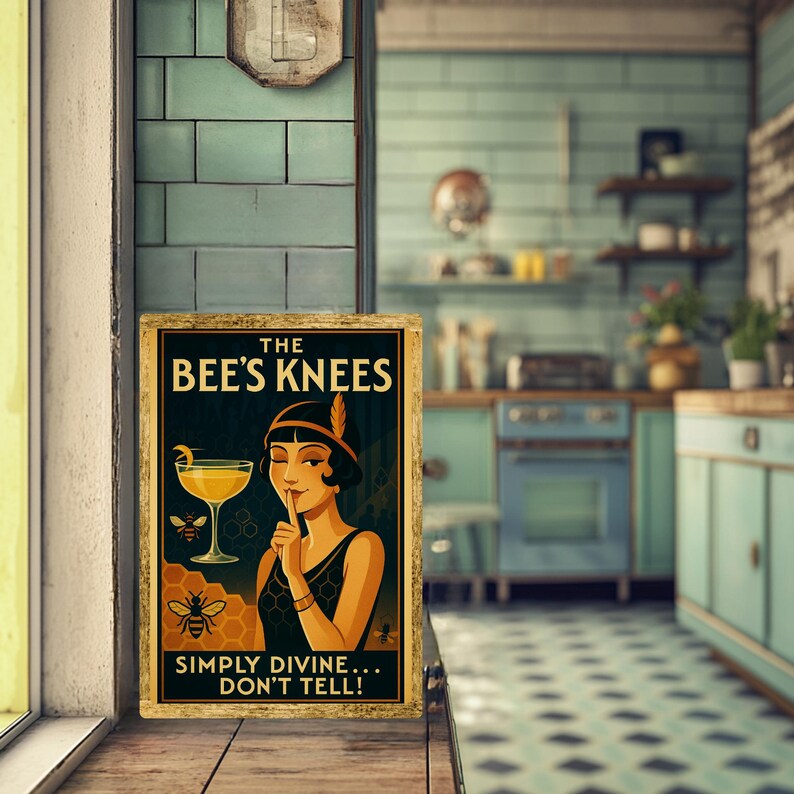 May include: A framed vintage-style sign with the text "THE BEE'S KNEES" and "SIMPLY DIVINE... DON'T TELL!". The artwork features a woman in a flapper dress, a cocktail, and bees. The sign has a gold-colored frame.