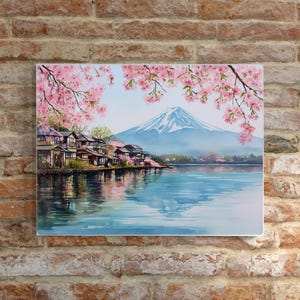 Peut inclure: Peinture &agrave; l'aquarelle d'un paysage japonais avec le Mont Fuji, un lac et des maisons traditionnelles. Des fleurs de cerisier roses encadrent le haut de l'image. La montagne a un sommet enneig&eacute; et l'eau refl&egrave;te le ciel et le paysage.