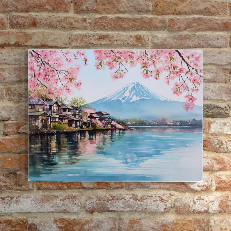 Peut inclure: Peinture &agrave; l'aquarelle d'un paysage japonais avec le Mont Fuji, un lac et des maisons traditionnelles. Des fleurs de cerisier roses encadrent le haut de l'image. La montagne a un sommet enneig&eacute; et l'eau refl&egrave;te le ciel et le paysage.