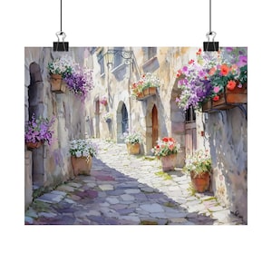 May include: A watercolour painting depicting a narrow, cobbled street in a European village. The street is flanked by stone buildings with arched doorways and windows. Flower boxes filled with colourful flowers hang from the buildings. The street is bathed in sunlight.