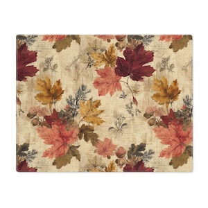 May include: Rectangular placemat featuring a vintage-style autumn leaf pattern. The design includes red, orange, and yellow maple leaves, along with botanical illustrations, on a beige background. The placemat is a decorative item for the dining table.