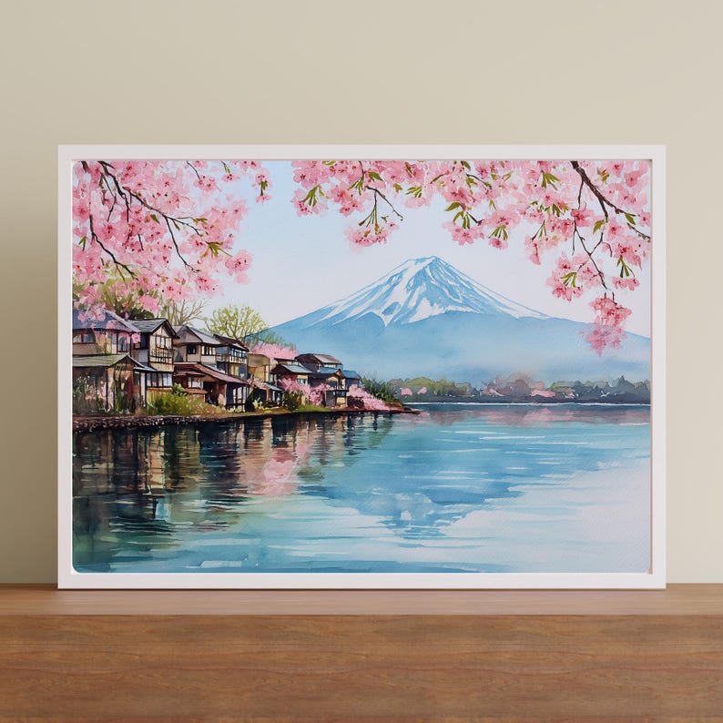 Peut inclure: Peinture &agrave; l'aquarelle d'un paysage japonais avec le Mont Fuji en arri&egrave;re-plan. Des cerisiers en fleurs roses encadrent la montagne et un lac. Des maisons traditionnelles bordent le rivage, se refl&eacute;tant dans l'eau. L'&oelig;uvre est encadr&eacute;e d'un cadre blanc.
