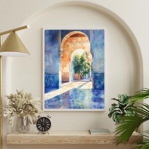 Pu&ograve; includere: Un dipinto ad acquerello di un cortile con archi e pavimenti in piastrelle blu. Il sole splende attraverso gli archi, proiettando lunghe ombre sul terreno. Il dipinto &egrave; incorniciato in una cornice bianca.
