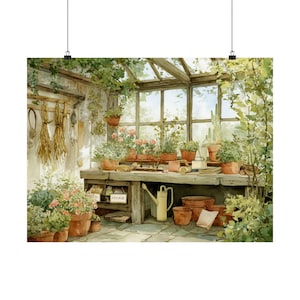 May include: Watercolor print of a sunlit greenhouse interior. The scene features a wooden potting table with various potted plants, gardening tools, and a yellow watering can. The background includes large windows and lush greenery.
