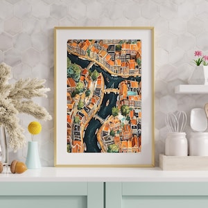 May include: A watercolour painting depicting an aerial view of a city with canals and buildings. The buildings are predominantly orange and brown with some green trees. The canals are dark blue and there are boats on the water.