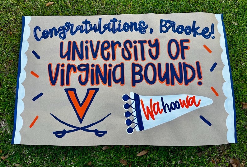 May include: A hand-painted sign on a tan background with the words "Congratulations, Brooke!" and "UNIVERSITY OF VIRGINIA BOUND!" in blue and orange. Includes the University of Virginia logo and "Wahoowa".