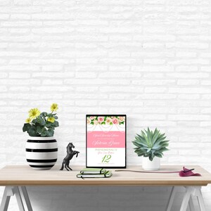 May include: A printable sign with a pink background and floral design. The text on the sign reads "Your Graduation Party" and "Gloria Grace" with the date "Phenomenal 13" and the number "12".