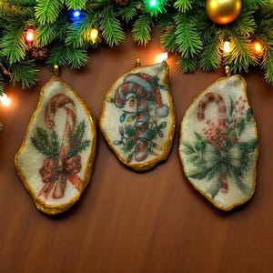 May include: Three Christmas ornaments with gold edges and glittery white interiors. Each features a candy cane design with red, green, and white accents. The ornaments are hanging in front of a brown background with a Christmas tree branch.