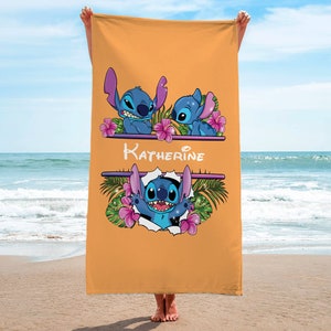 May include: A yellow beach towel with a personalized name "Katherine" and three blue Stitch characters from the Disney movie Lilo & Stitch. The characters are surrounded by pink flowers and green leaves.