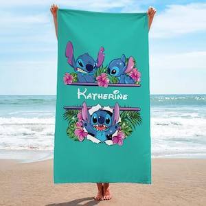May include: A turquoise beach towel with a personalized name "Katherine" printed in white. The towel features a repeating pattern of Stitch characters from the Disney movie Lilo & Stitch, surrounded by tropical flowers and leaves.