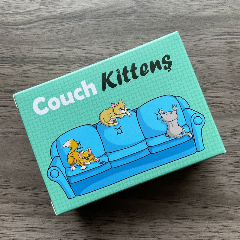 May include: A blue couch with three cats on it. The couch has a green background with the words "Couch Kittens" printed on it.
