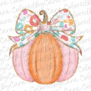 May include: A pink and orange pumpkin with a white and colorful bow. The pumpkin has a glittery texture and the bow has a gold glitter trim.