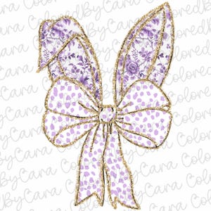 May include: A large purple and white bow with gold glitter accents. The bow is made of fabric with a floral pattern and white polka dots.