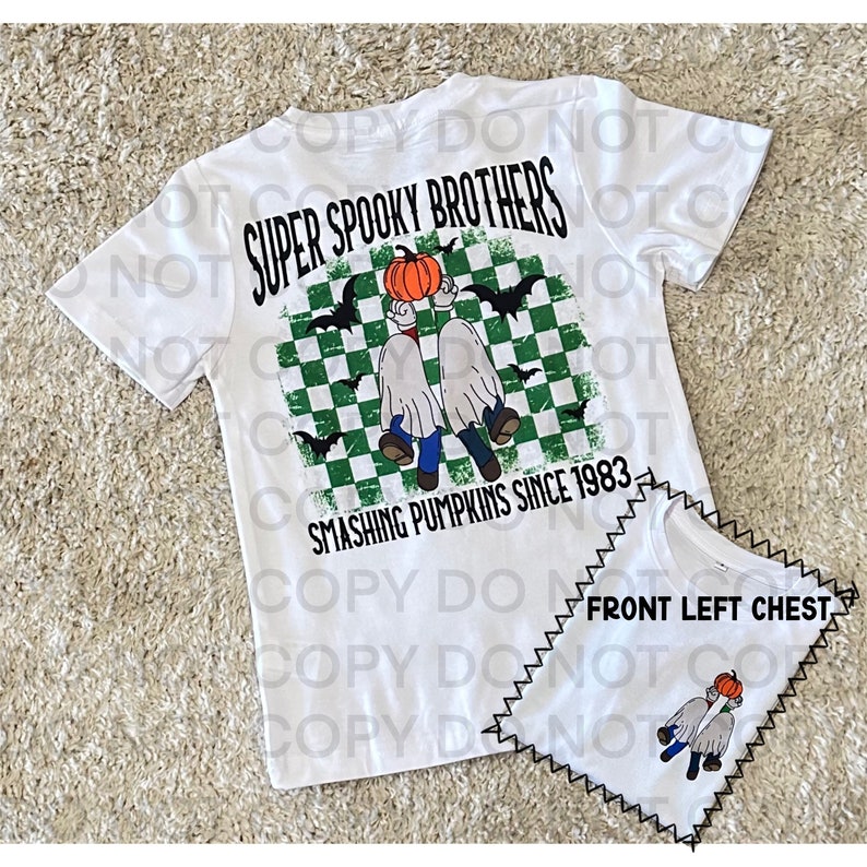 Pu&ograve; includere: Maglietta bianca con uno sfondo a scacchi verde e bianco, due fantasmi che tengono una zucca e il testo "Super Spooky Brothers Smashing Pumpkins Since 1983".