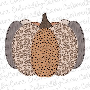 May include: A brown, beige, and gray pumpkin with a leopard print design. The pumpkin is made of fabric and has a stitched seam around the edges.
